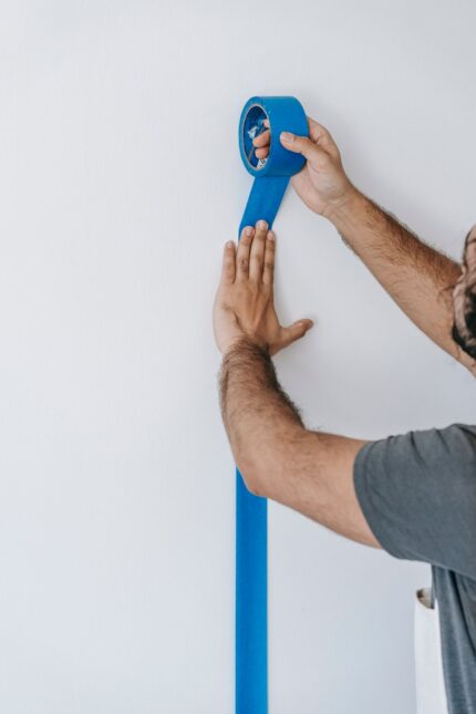 Blue low-tack painter’s tape applied to a wall edge